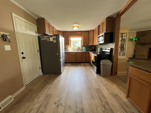 7427 Mccurry Rd, Roscoe, IL 61073 - kitchen featuring stainless steel appliances, a sink, light wood-style flooring, ornamental molding, and brown cabinets