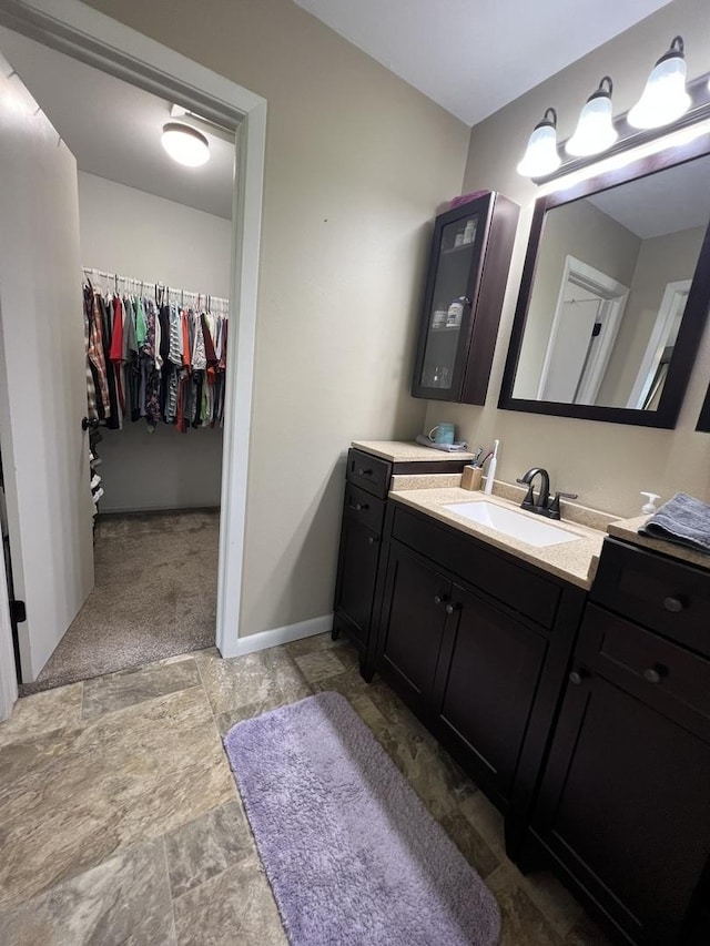 7427 Mccurry Rd, Roscoe, IL 61073 - bathroom featuring stone finish floors, vanity, and a spacious closet
