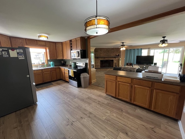 7427 Mccurry Rd, Roscoe, IL 61073 - kitchen with appliances with stainless steel finishes, a sink, open floor plan, brown cabinetry, and a ceiling fan
