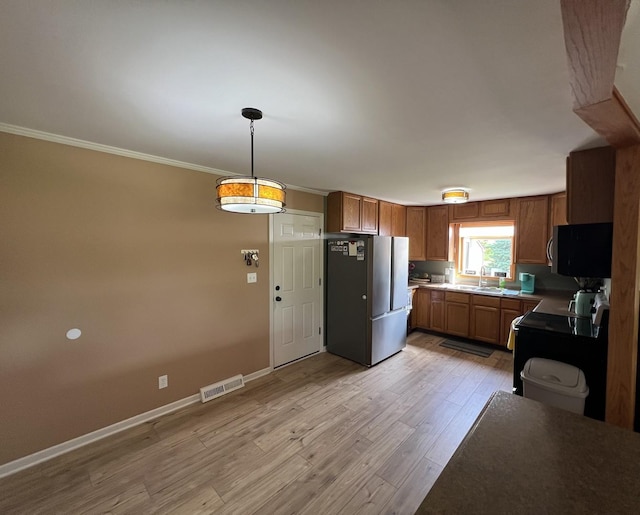7427 Mccurry Rd, Roscoe, IL 61073 - kitchen featuring stainless steel appliances, light wood-type flooring, a sink, brown cabinetry, and crown molding