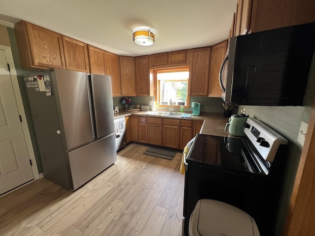 7427 Mccurry Rd, Roscoe, IL 61073 - kitchen with appliances with stainless steel finishes, a sink, brown cabinetry, and light wood-type flooring