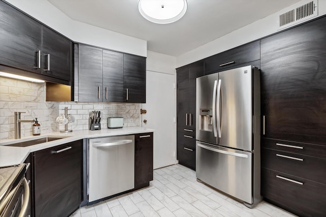 6033 N Sheridan Rd Unit 21D, Chicago, IL 60660 - kitchen with appliances with stainless steel finishes, a sink, modern cabinets, light countertops, and decorative backsplash