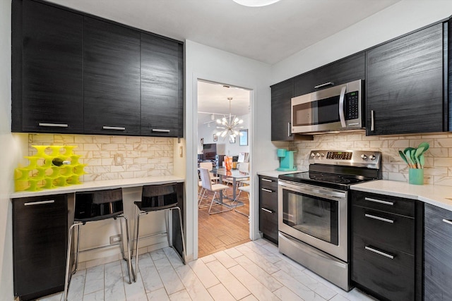 6033 N Sheridan Rd Unit 21D, Chicago, IL 60660 - kitchen with stainless steel appliances, dark cabinets, light countertops, and decorative backsplash