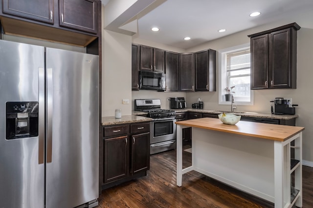 4639 S Saint Lawrence Ave Unit 2, Chicago, IL 60653 - kitchen with appliances with stainless steel finishes, butcher block countertops, dark wood-type flooring, dark brown cabinets, and recessed lighting
