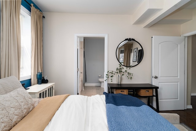 4639 S Saint Lawrence Ave Unit 2, Chicago, IL 60653 - bedroom featuring multiple windows, baseboards, connected bathroom, and wood finished floors