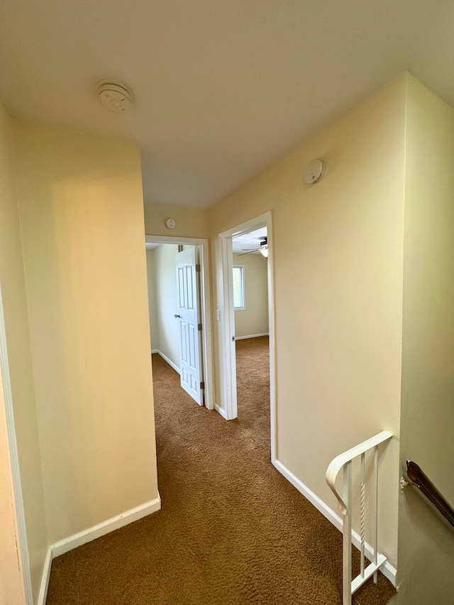 corridor featuring carpet floors and baseboards
