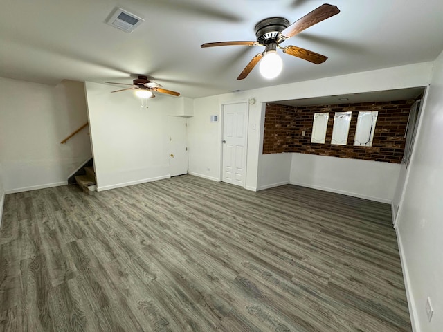 unfurnished living room with ceiling fan, baseboards, wood finished floors, and stairs
