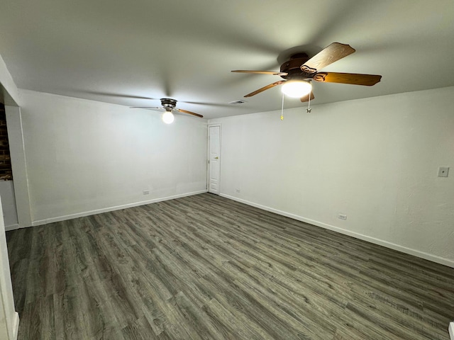 empty room featuring ceiling fan, dark wood-style floors, and baseboards