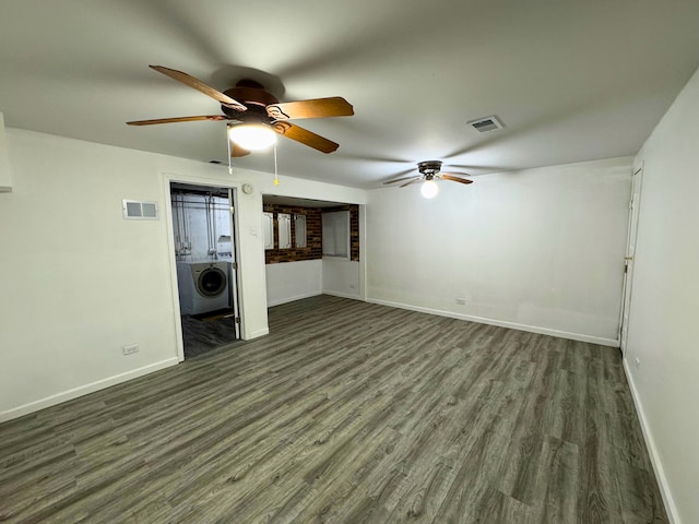unfurnished living room with washer / dryer, a ceiling fan, wood finished floors, and baseboards