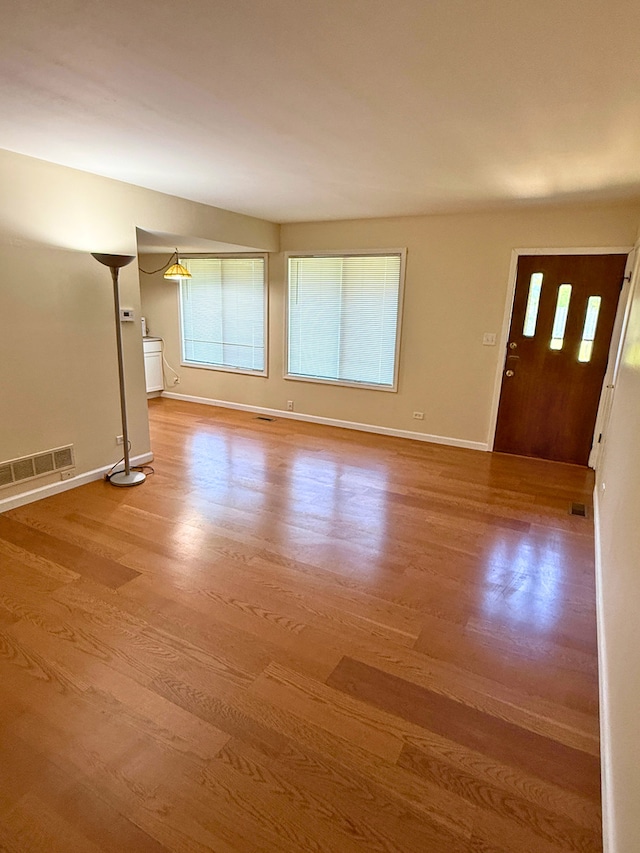 unfurnished living room featuring wood finished floors and baseboards