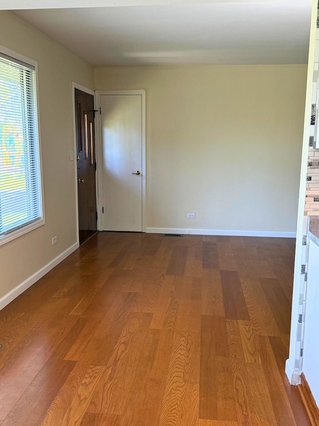 empty room featuring wood finished floors and baseboards