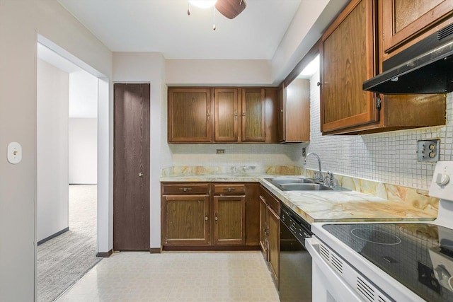 kitchen with dishwasher, a sink, under cabinet range hood, light countertops, and tasteful backsplash
