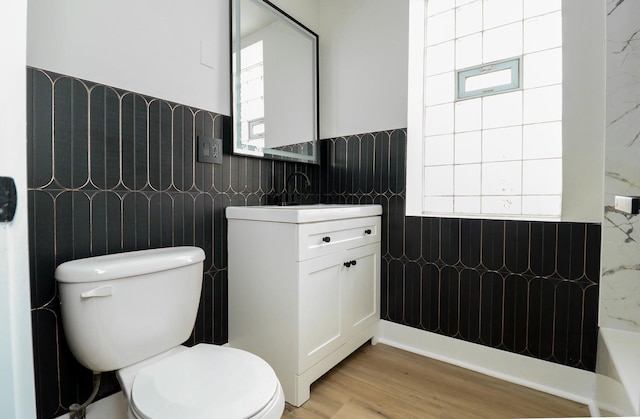 6110 S Saint Lawrence Ave, Chicago, IL 60637 - bathroom with tile walls, toilet, vanity, a wainscoted wall, and wood finished floors