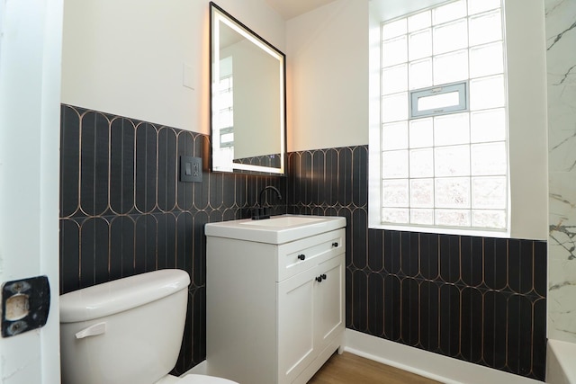 6110 S Saint Lawrence Ave, Chicago, IL 60637 - bathroom with tile walls, healthy amount of natural light, vanity, toilet, and a wainscoted wall