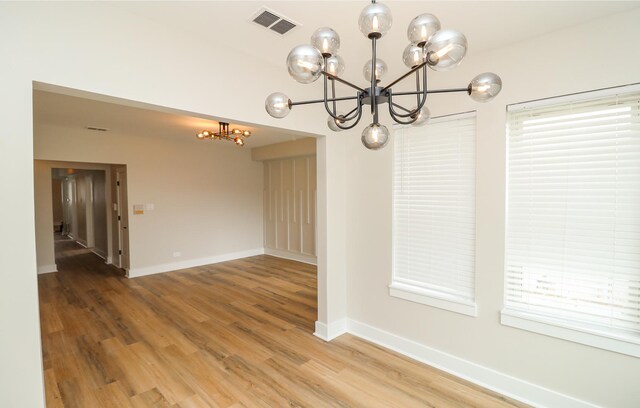 6110 S Saint Lawrence Ave, Chicago, IL 60637 - empty room featuring a chandelier, light wood finished floors, baseboards, and healthy amount of natural light