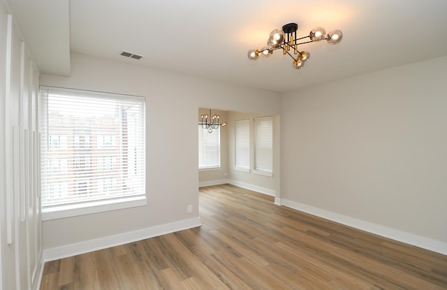 6110 S Saint Lawrence Ave, Chicago, IL 60637 - empty room with a chandelier, light wood-style floors, healthy amount of natural light, and baseboards