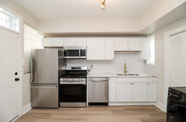6110 S Saint Lawrence Ave, Chicago, IL 60637 - kitchen featuring appliances with stainless steel finishes, a sink, white cabinets, and tasteful backsplash