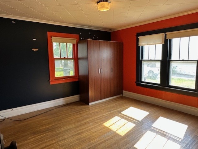 301 S Hebbard St, Joliet, IL 60433 - unfurnished bedroom with wood finished floors, crown molding, baseboards, and a closet