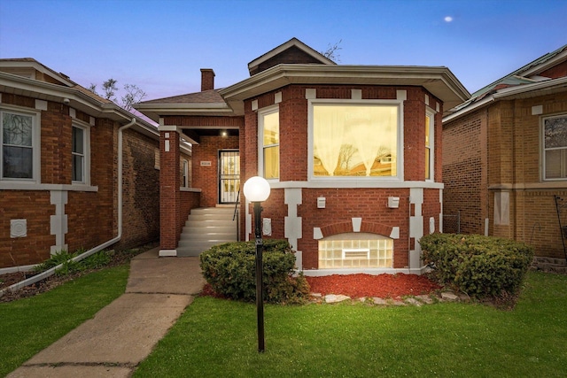 8214 S Paxton Ave, Chicago, IL 60617 - view of front of house with brick siding, a lawn, and a chimney