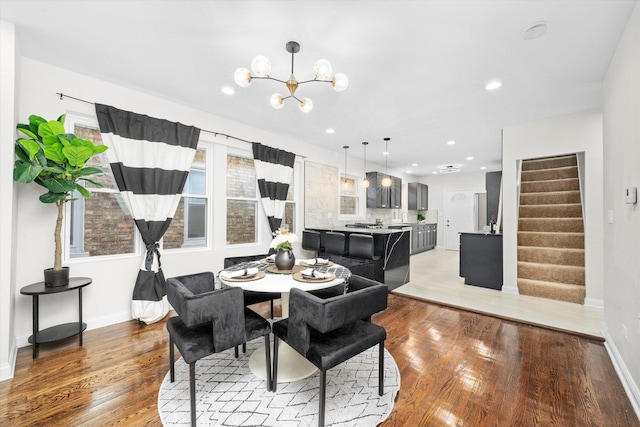 8214 S Paxton Ave, Chicago, IL 60617 - dining area with light wood-type flooring, stairs, a chandelier, baseboards, and recessed lighting