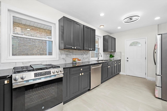 8214 S Paxton Ave, Chicago, IL 60617 - kitchen with stainless steel appliances, a sink, backsplash, dark countertops, and recessed lighting