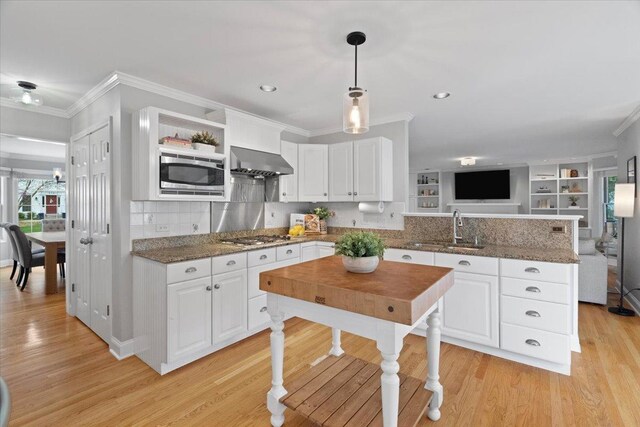 519 Long Hill Rd, Gurnee, IL 60031 - kitchen featuring a sink, appliances with stainless steel finishes, a peninsula, wall chimney range hood, and crown molding