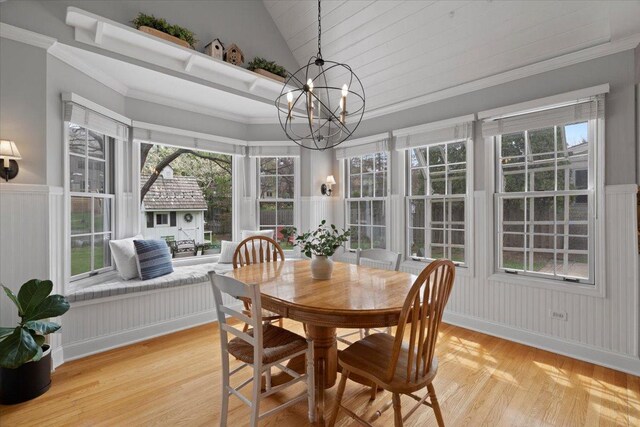 519 Long Hill Rd, Gurnee, IL 60031 - dining area with a chandelier, a decorative wall, light wood-style flooring, vaulted ceiling, and a wainscoted wall