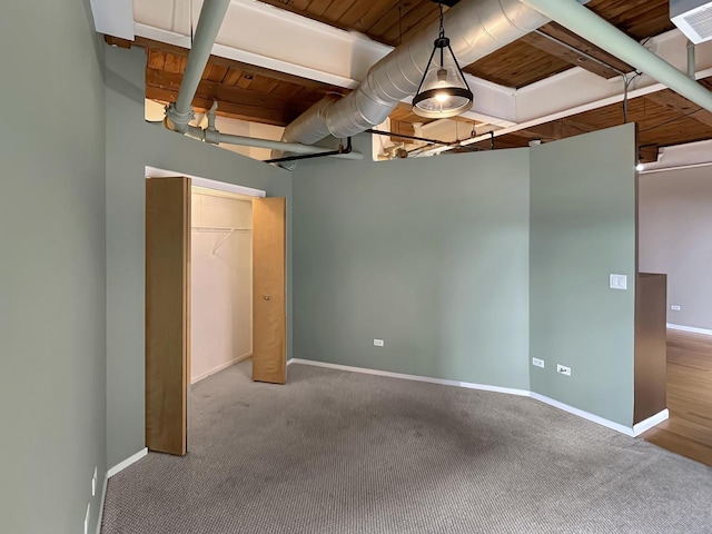 unfurnished bedroom featuring carpet, baseboards, and a closet