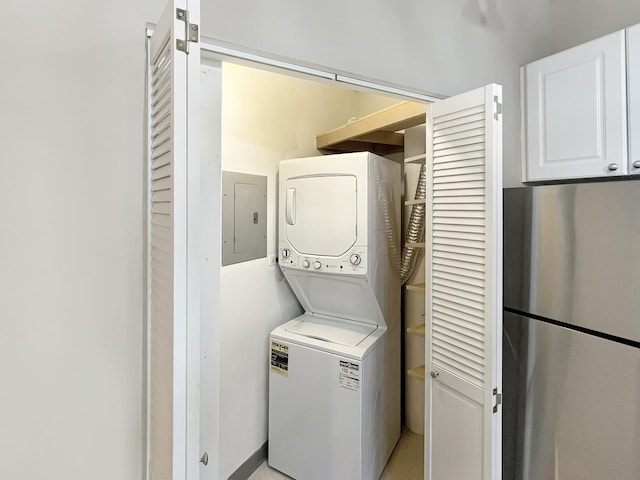 clothes washing area featuring stacked washer and clothes dryer and electric panel