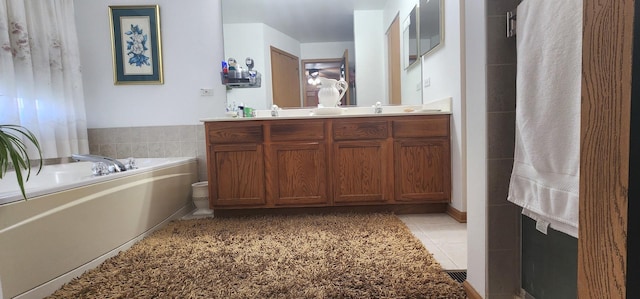bathroom featuring a garden tub, double vanity, and tile patterned flooring