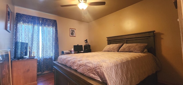 bedroom featuring dark wood-style floors, lofted ceiling, and a ceiling fan