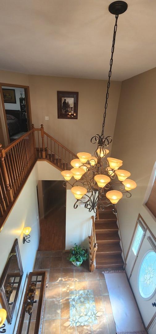 staircase featuring tile patterned floors and a chandelier