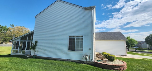view of property exterior with a yard and a sunroom