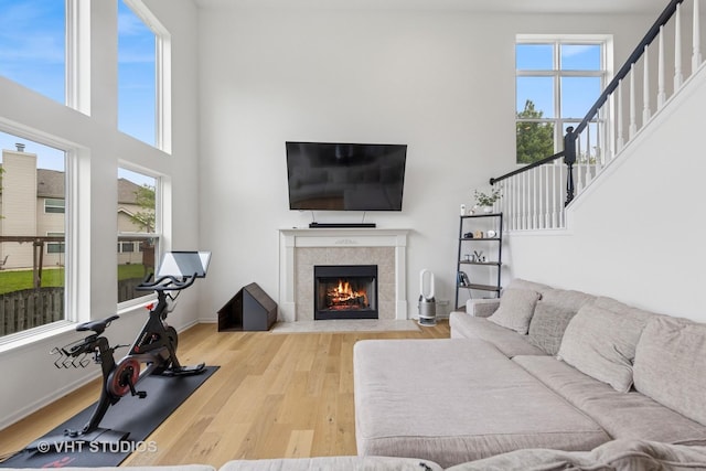 635 Mansfield Way, Oswego, IL 60543 - living area with plenty of natural light, a high ceiling, wood finished floors, a tile fireplace, and stairs