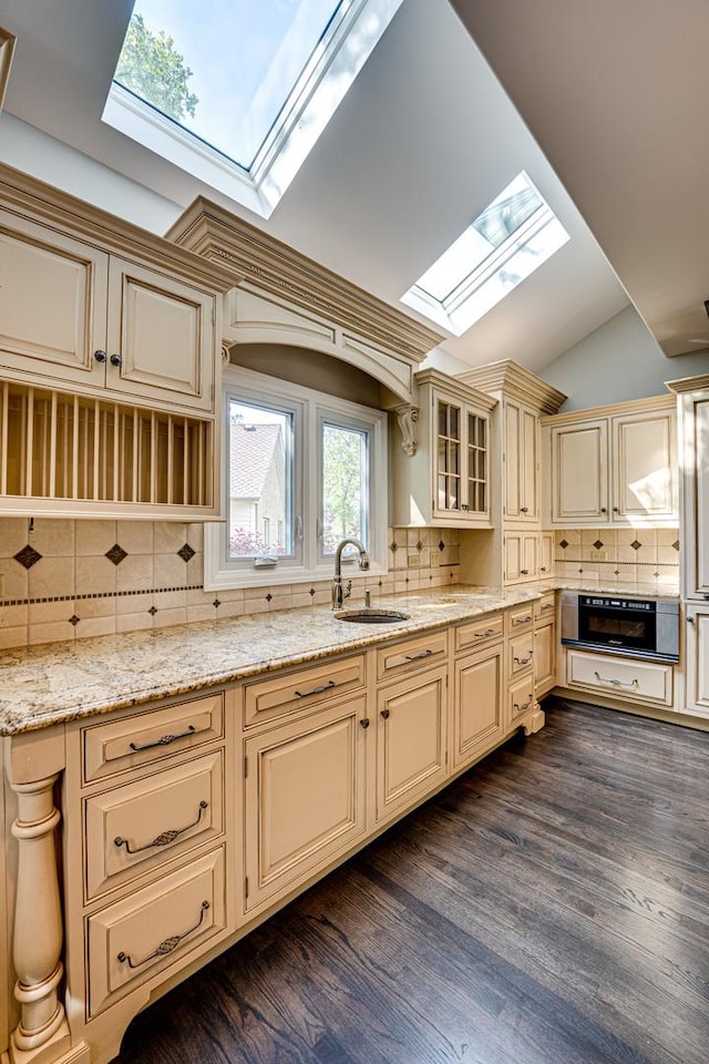 1565 Winberie Ct, Naperville, IL 60564 - kitchen featuring a skylight, cream cabinets, a sink, backsplash, and light stone countertops