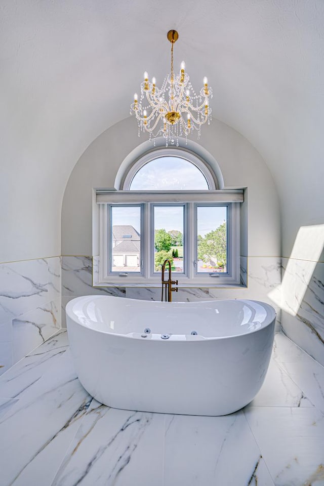 1565 Winberie Ct, Naperville, IL 60564 - bathroom featuring a wainscoted wall, a soaking tub, marble tiled flooring, tile walls, and a chandelier