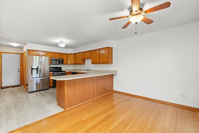 11046 Quail Dr, Mokena, IL 60448 - kitchen with appliances with stainless steel finishes, a peninsula, light wood-style floors, brown cabinetry, and light countertops