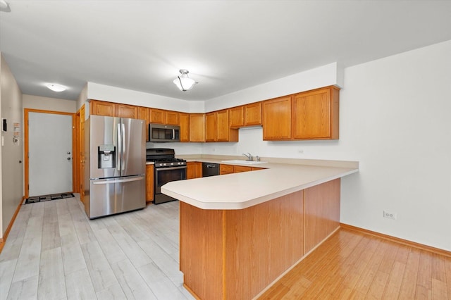 11046 Quail Dr, Mokena, IL 60448 - kitchen featuring stainless steel appliances, brown cabinetry, a peninsula, light wood-style flooring, and baseboards
