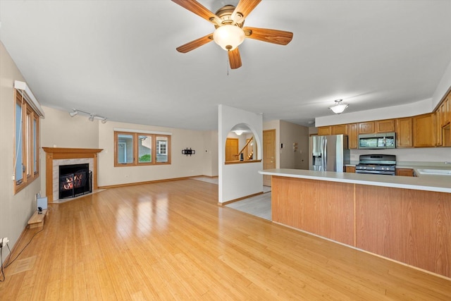 11046 Quail Dr, Mokena, IL 60448 - kitchen with appliances with stainless steel finishes, a fireplace with flush hearth, light countertops, and light wood finished floors