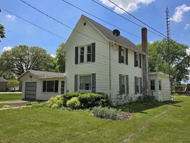 320 N Pearl St, Forrest, IL 61741 - view of front facade with a front lawn, a chimney, and a garage
