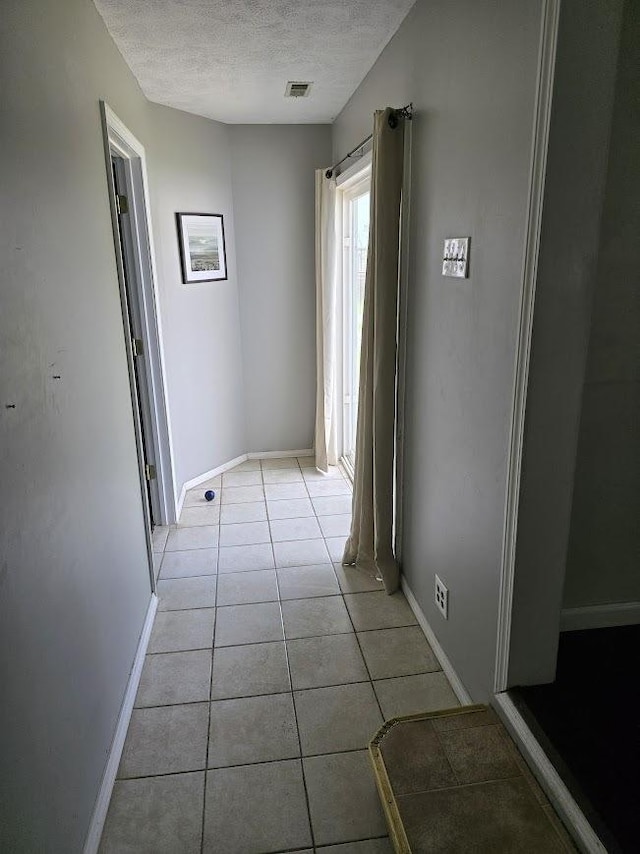 320 N Pearl St, Forrest, IL 61741 - corridor with a textured ceiling, light tile patterned floors, and baseboards