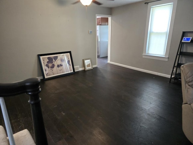 320 N Pearl St, Forrest, IL 61741 - unfurnished living room featuring a ceiling fan, dark wood-type flooring, and baseboards