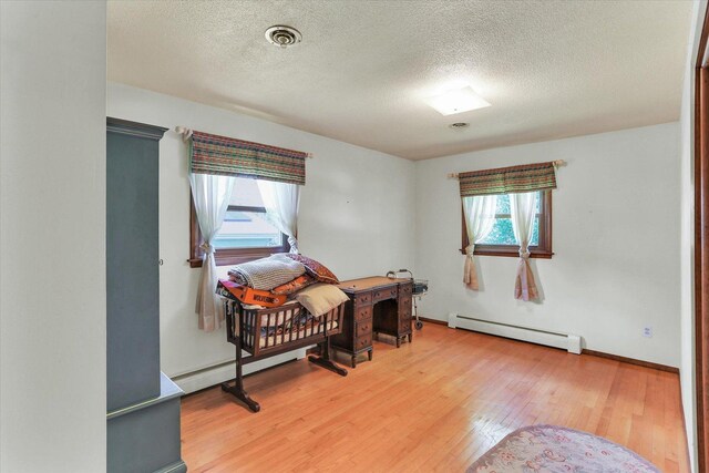 7 Birch Ln, Villa Grove, IL 61956 - office space featuring a baseboard radiator, light wood-style flooring, a textured ceiling, and baseboards