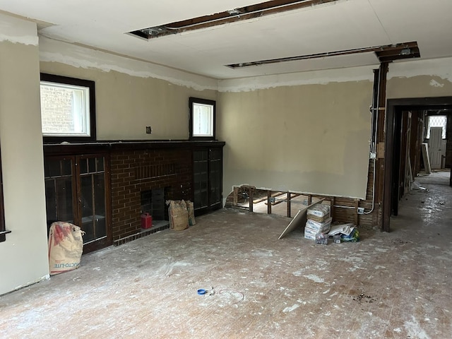 unfurnished living room featuring a brick fireplace