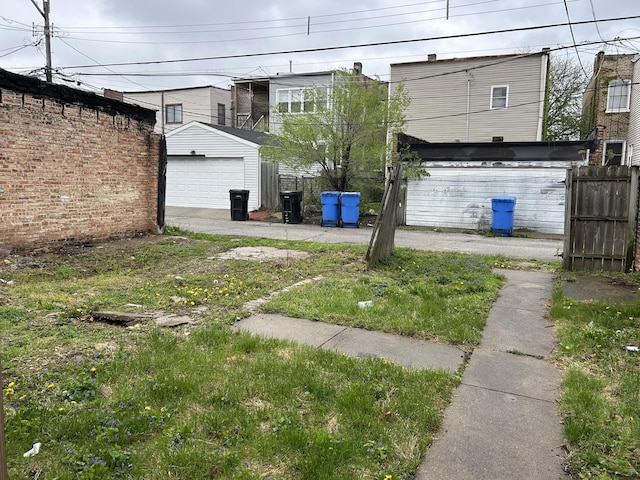 view of yard featuring fence, an outdoor structure, and a detached garage