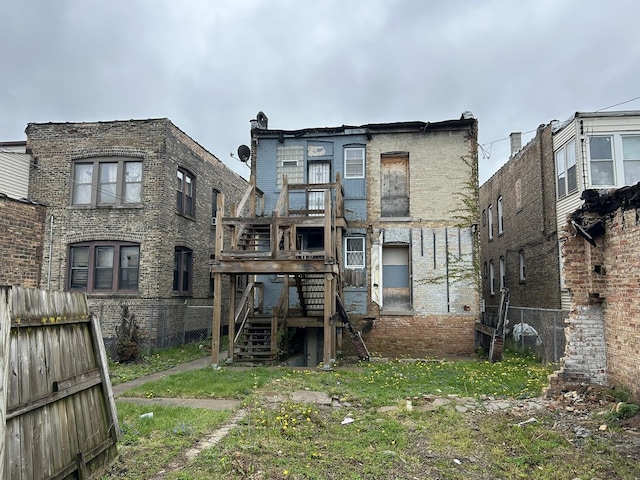 rear view of house featuring stairway, brick siding, fence, and a wooden deck