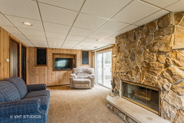 898 Shorewood Dr, Bartlett, IL 60103 - carpeted living room featuring a paneled ceiling, wood walls, and a stone fireplace