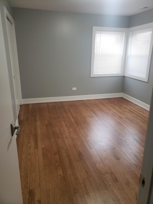 spare room with wood finished floors and baseboards