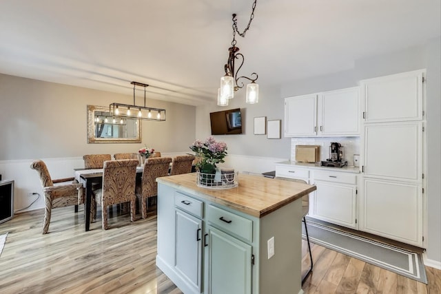 405 W Ivy Ln Unit 4A, Arlington Heights, IL 60004 - kitchen with white cabinetry, a center island, light wood-style floors, butcher block counters, and pendant lighting