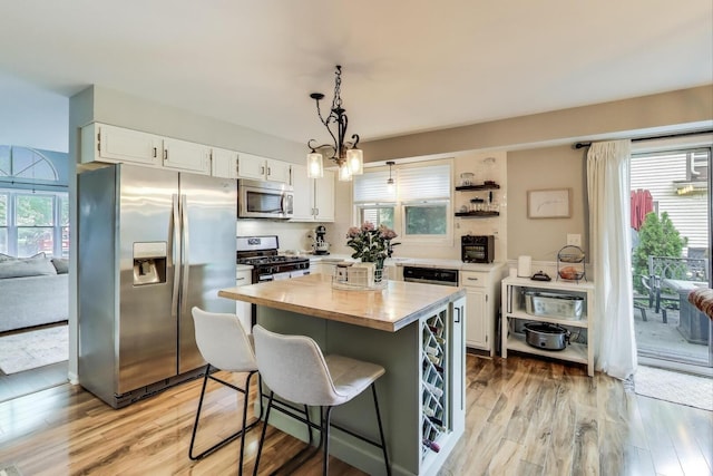 405 W Ivy Ln Unit 4A, Arlington Heights, IL 60004 - kitchen with appliances with stainless steel finishes, white cabinetry, light wood-type flooring, and healthy amount of natural light